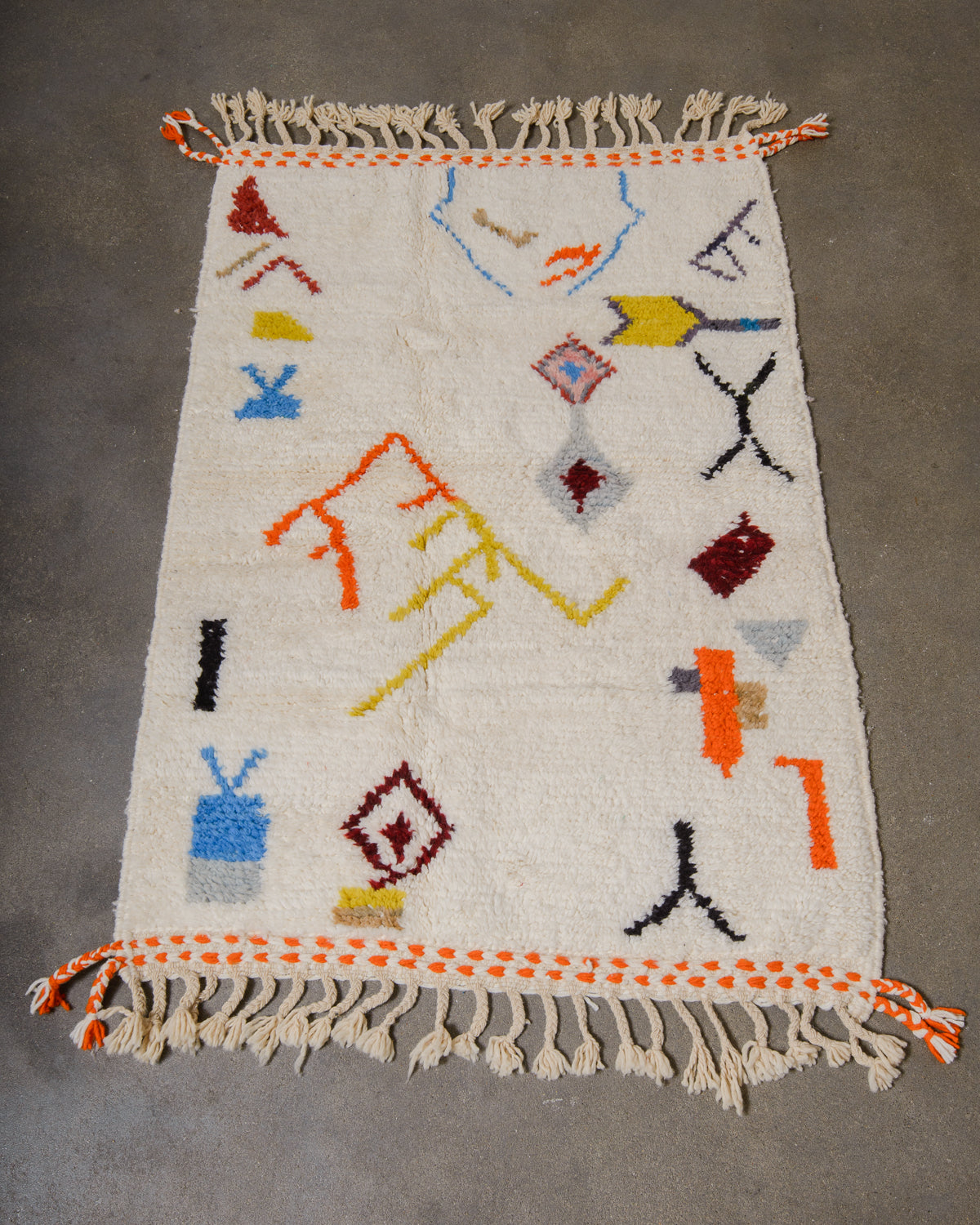 Small rug with colorful geometric patterns on a gray background